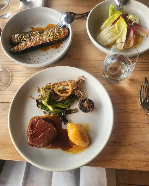 Beef eye fillet with grilled spring onion, burnt carrots with pumpkin seed dukkha, and an orange, witloof and fennel salad at Black Barn Bistro