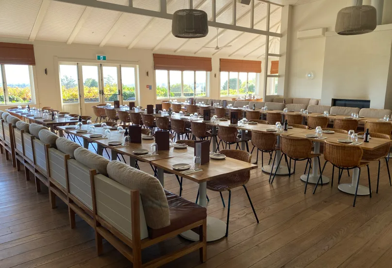 Black Barn Bistro dining room set for lunch, long tables beside the vineyard windows