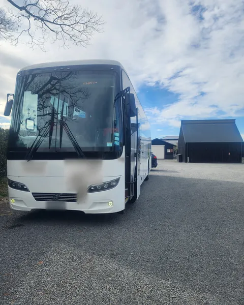 The group's full-size coach parked on the gravel at Black Barn Vineyards, Havelock North