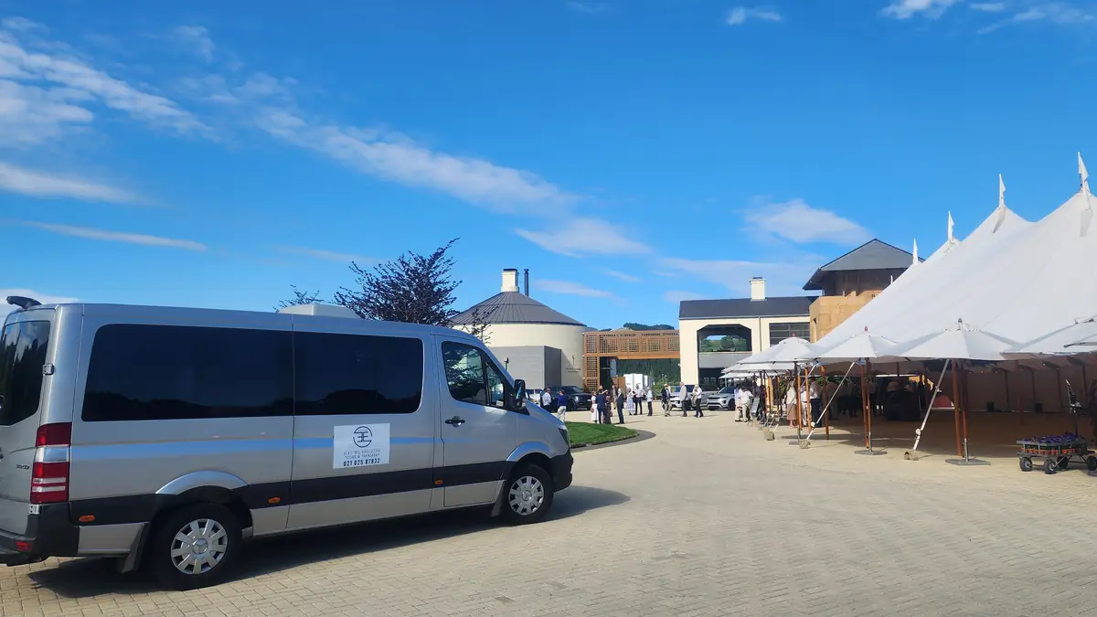 The Electric Executive Mercedes-Benz Sprinter waiting beside the marquee at a Hawke's Bay winery wedding reception