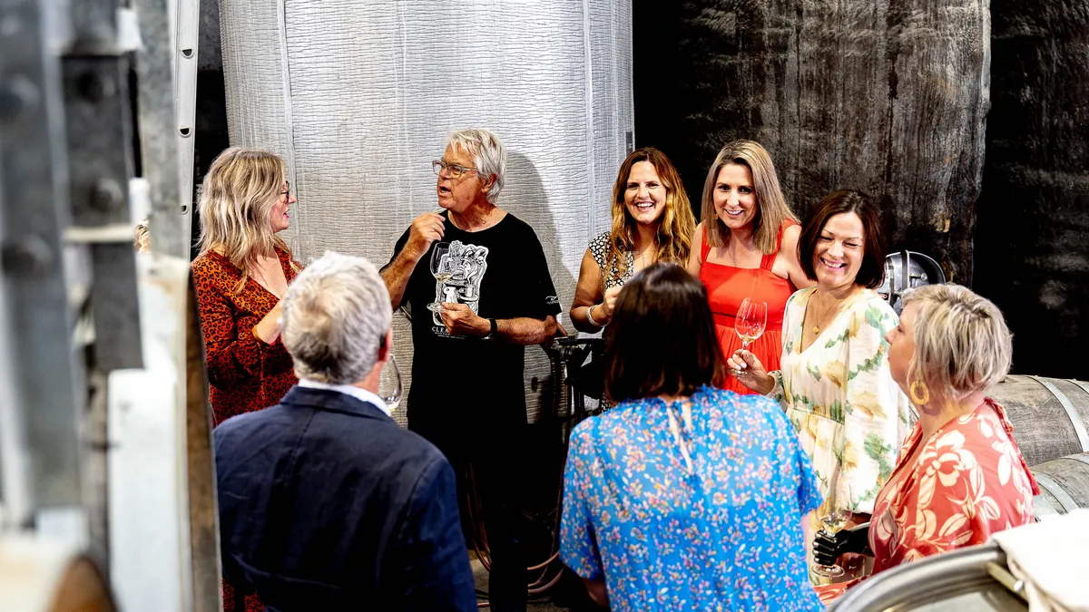 Guests at a hosted tasting among the barrels in a Hawke's Bay winery cellar