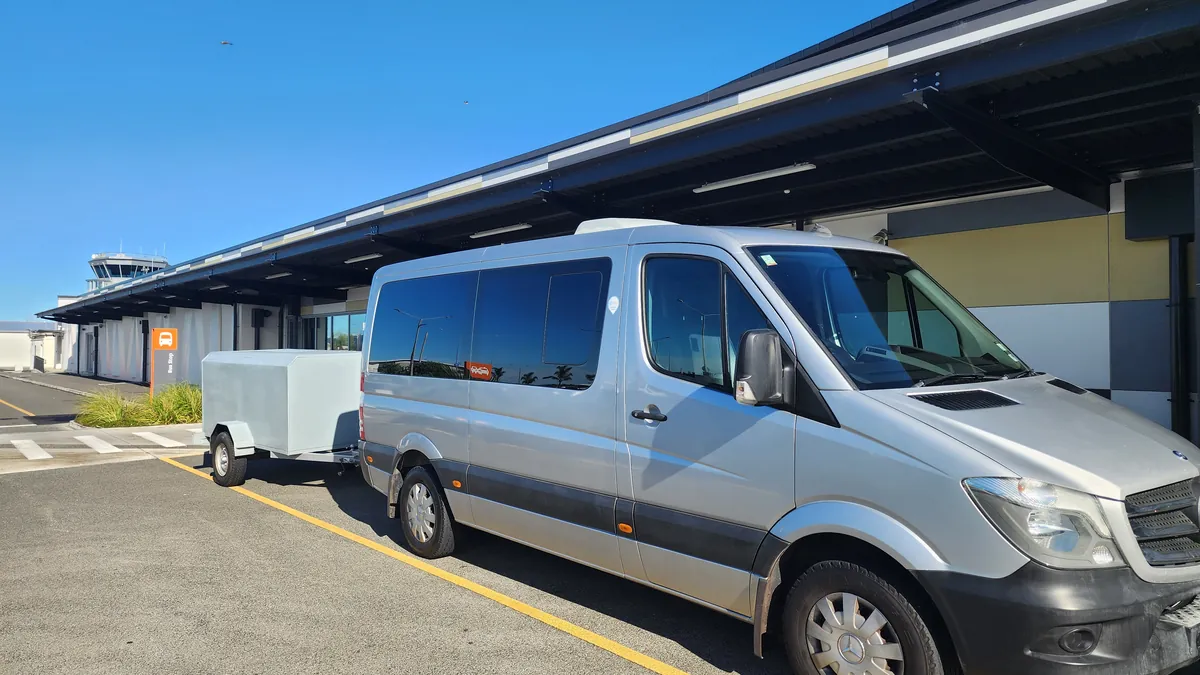 The Electric Executive Mercedes-Benz Sprinter and covered luggage trailer outside the terminal at Hawke's Bay Airport
