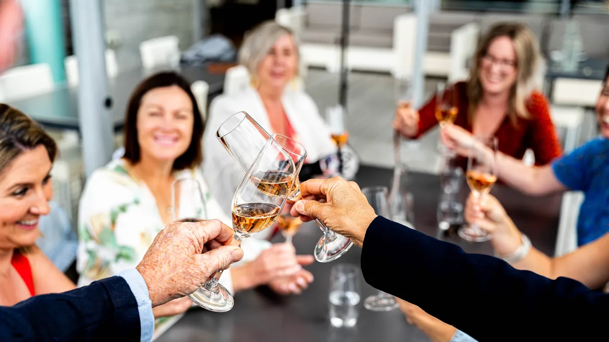 Guests raising their glasses around a long table at a hosted Hawke's Bay food and wine day