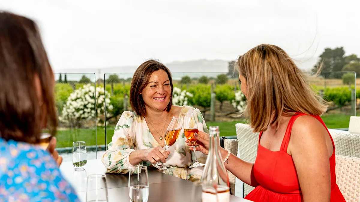 Guests tasting rose at a terrace table above the vines on the Great Wine Capital Discovery tour in Hawke's Bay
