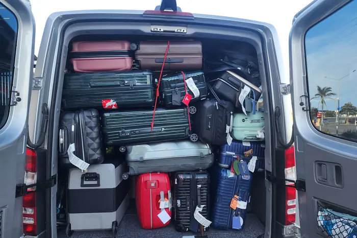 The rear of the Mercedes-Benz Sprinter fully loaded with suitcases
